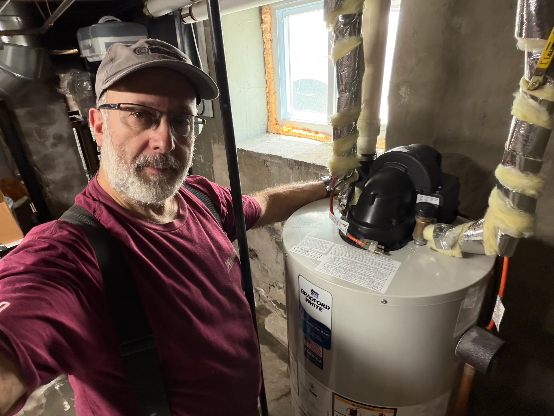 Technician beside new bradford white power vent water heater melrose